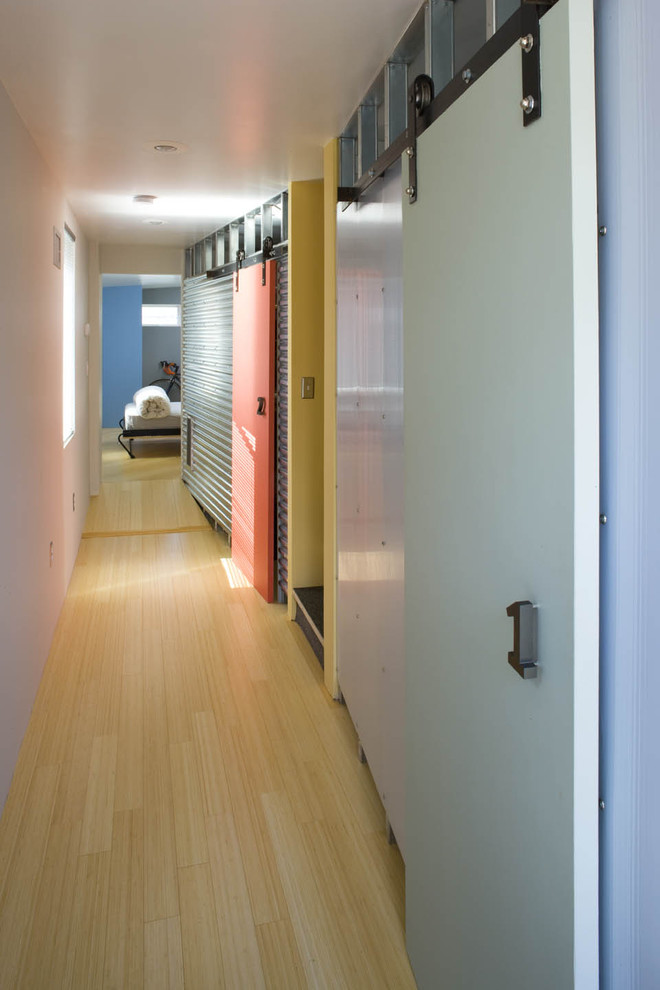 Aménagement d'un couloir industriel avec parquet clair, un mur blanc et un sol jaune.