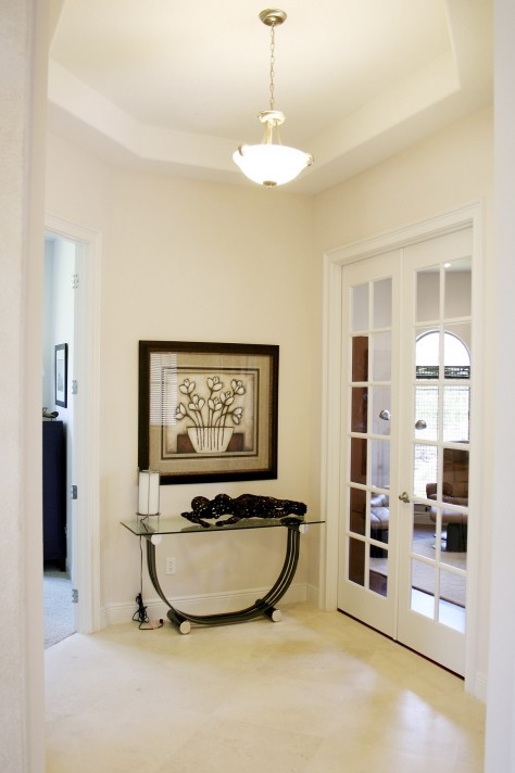 Example of a small minimalist ceramic tile hallway design in Orlando with white walls