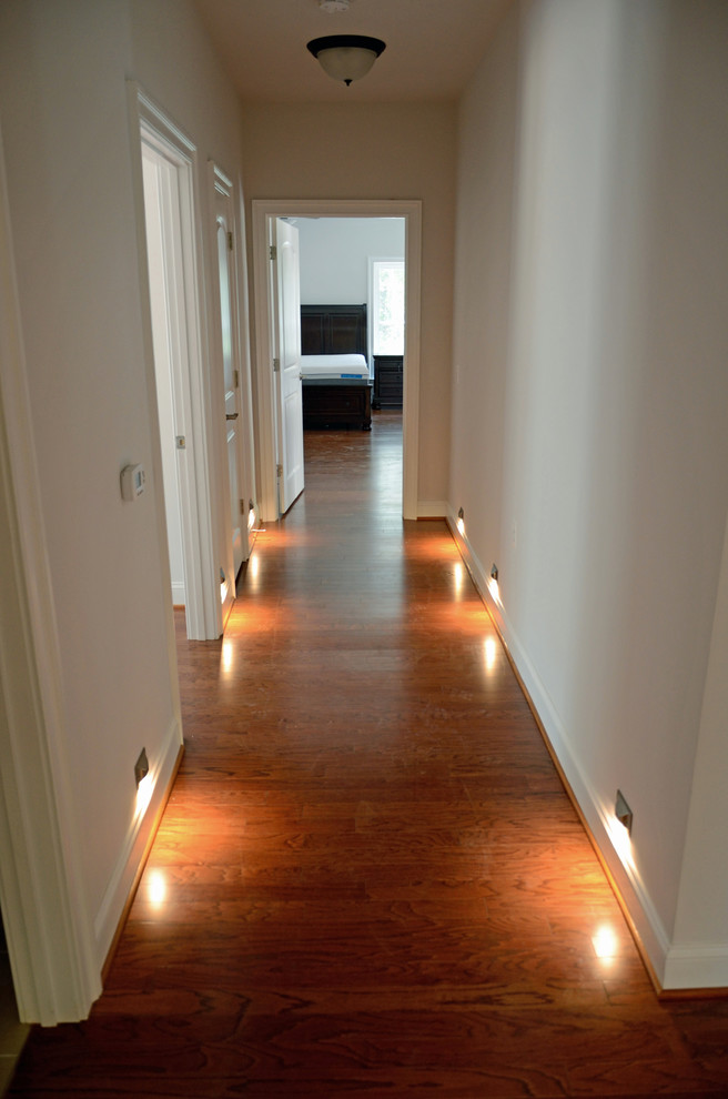 Mid-sized transitional medium tone wood floor hallway photo in DC Metro with white walls