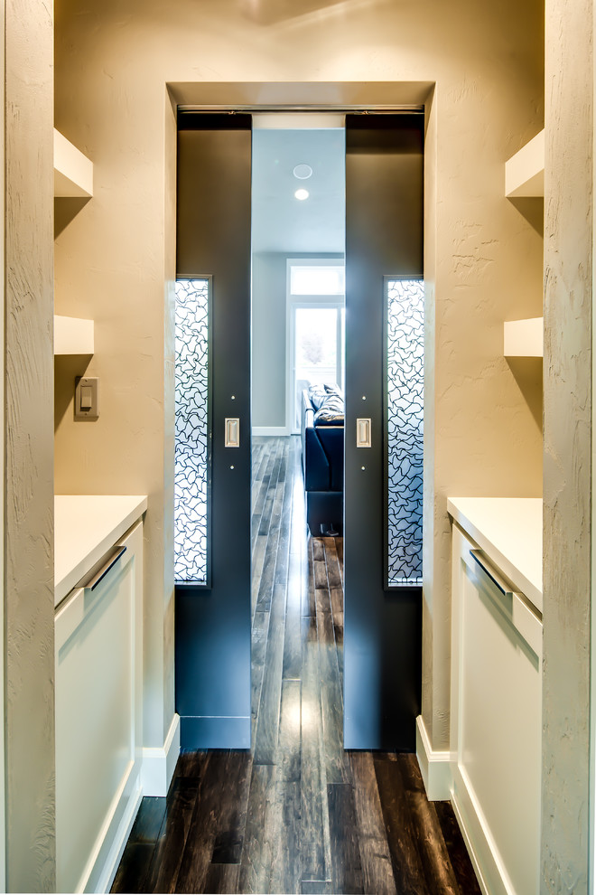 Ejemplo de recibidores y pasillos tradicionales renovados de tamaño medio con paredes grises y suelo de madera en tonos medios