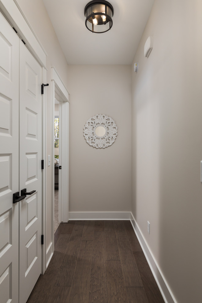 Inspiration for a coastal medium tone wood floor and brown floor hallway remodel in Grand Rapids with white walls