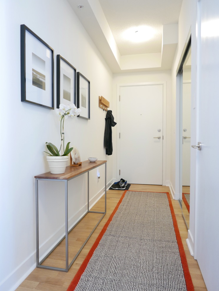 На фото: коридор среднего размера в современном стиле с белыми стенами и светлым паркетным полом