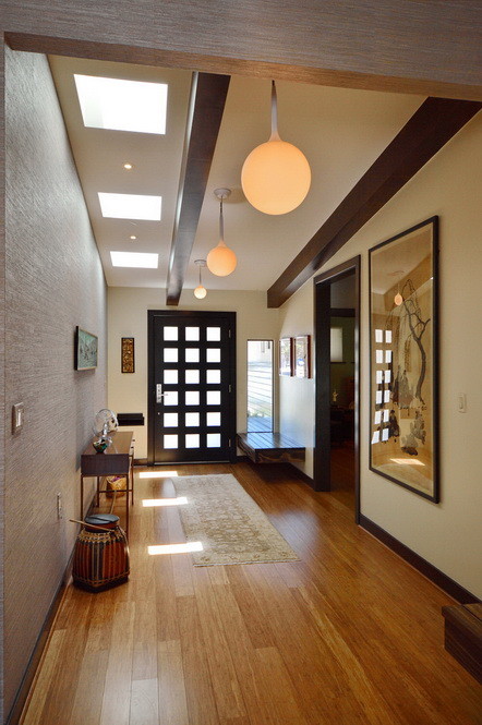 Idee per un grande ingresso o corridoio minimalista con pareti multicolore e pavimento in legno massello medio