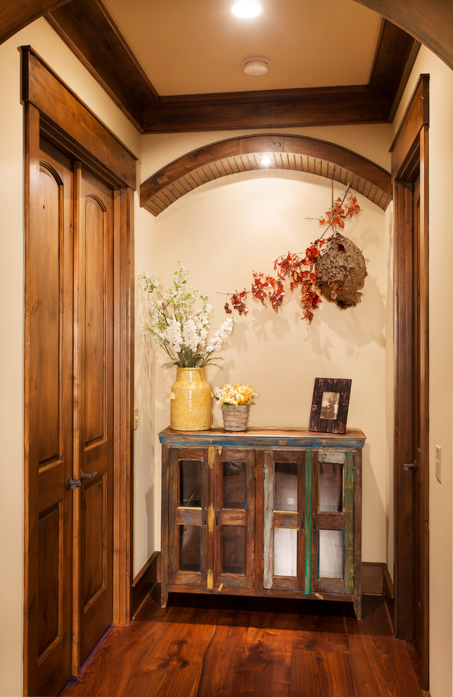 Esempio di un piccolo ingresso o corridoio rustico con pareti beige, parquet scuro e pavimento marrone
