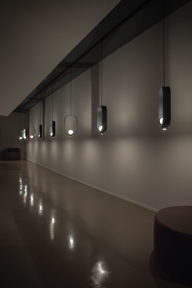 Idée de décoration pour un grand couloir design avec un mur gris, sol en béton ciré et un sol gris.