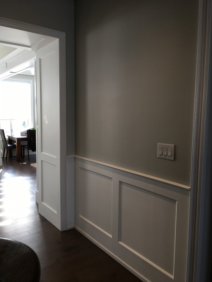 Inspiration pour un couloir design avec un mur gris et un sol marron.