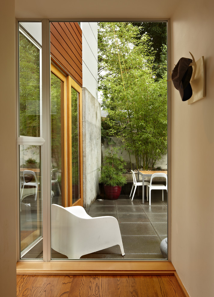 Imagen de recibidores y pasillos modernos con paredes beige y suelo de madera en tonos medios