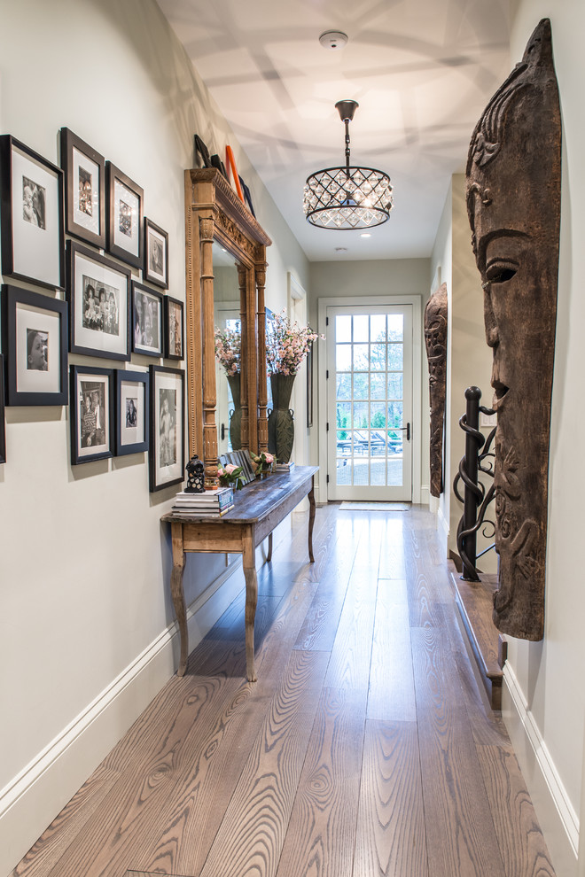 Example of a mid-sized transitional light wood floor hallway design in St Louis with beige walls