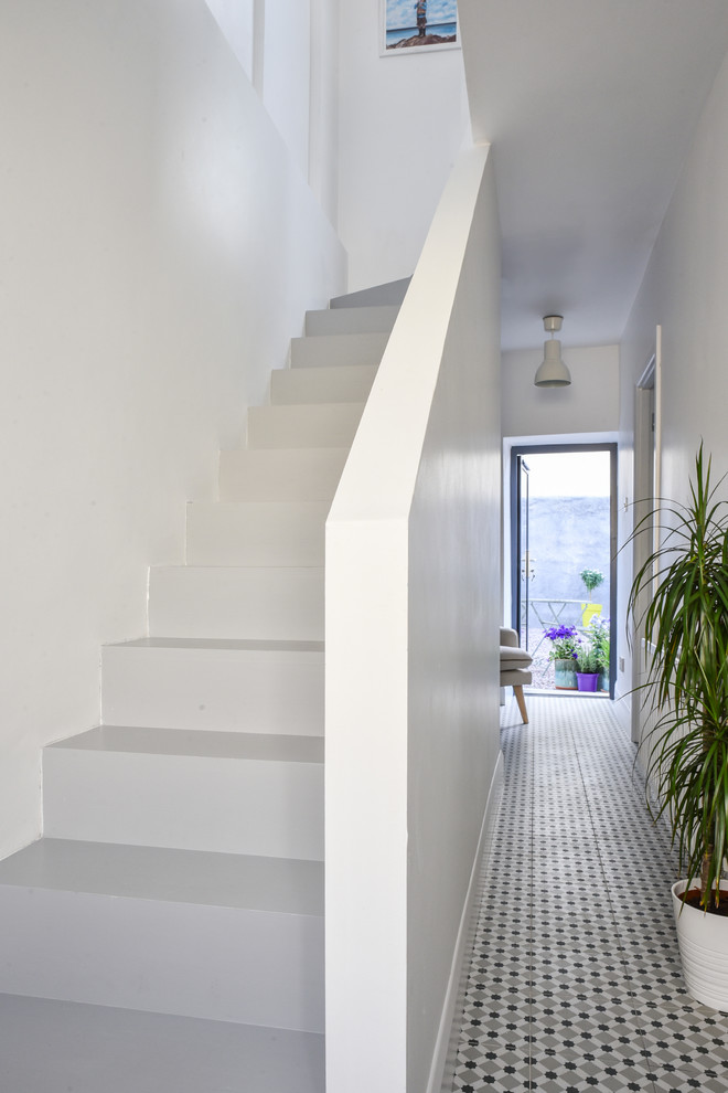 Immagine di un piccolo ingresso o corridoio design con pareti bianche, pavimento con piastrelle in ceramica e pavimento grigio