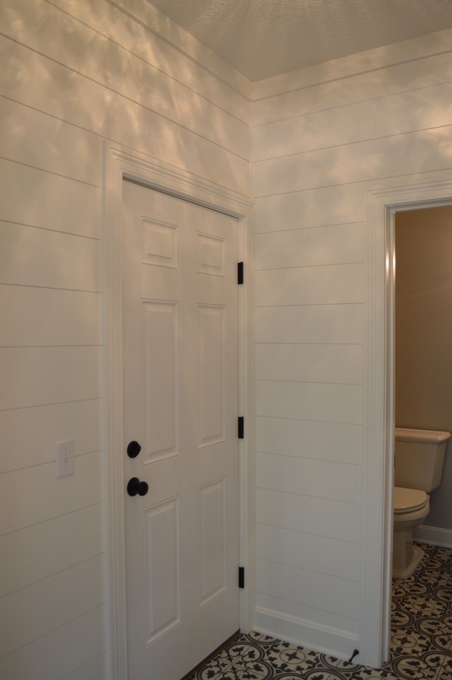 Cette image montre un couloir rustique de taille moyenne avec un mur blanc, un sol en carrelage de céramique et un sol multicolore.