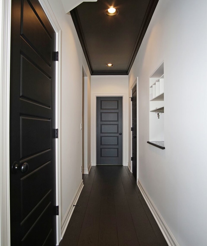 На фото: маленький коридор с белыми стенами, темным паркетным полом и черным полом для на участке и в саду