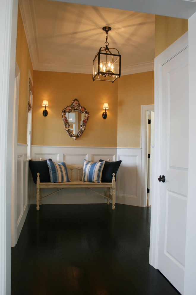 На фото: коридор в классическом стиле с желтыми стенами, темным паркетным полом и черным полом с