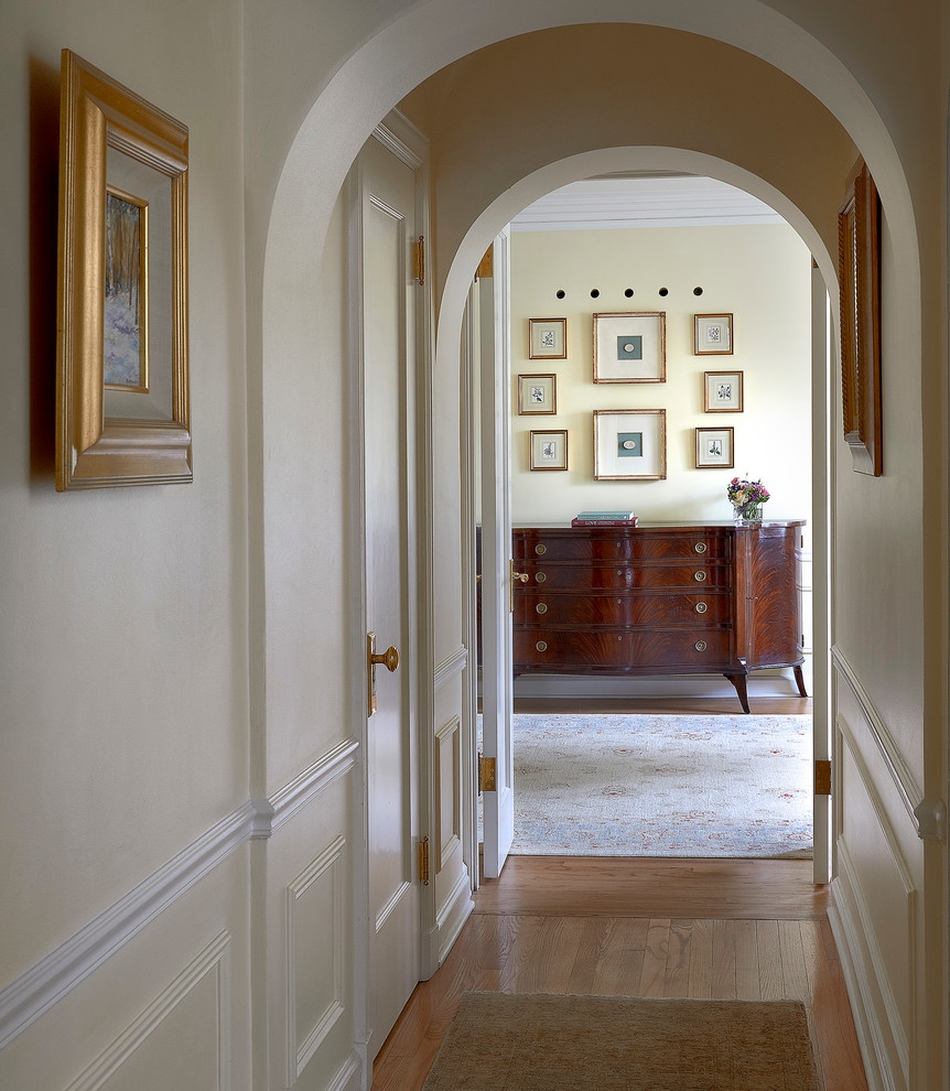 Foto de recibidores y pasillos tradicionales de tamaño medio con paredes blancas y suelo de madera en tonos medios