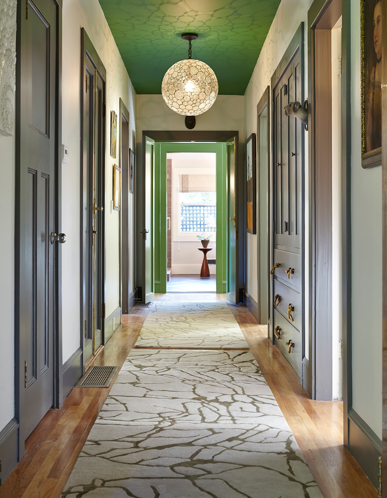 Example of a classic medium tone wood floor hallway design in San Francisco with white walls