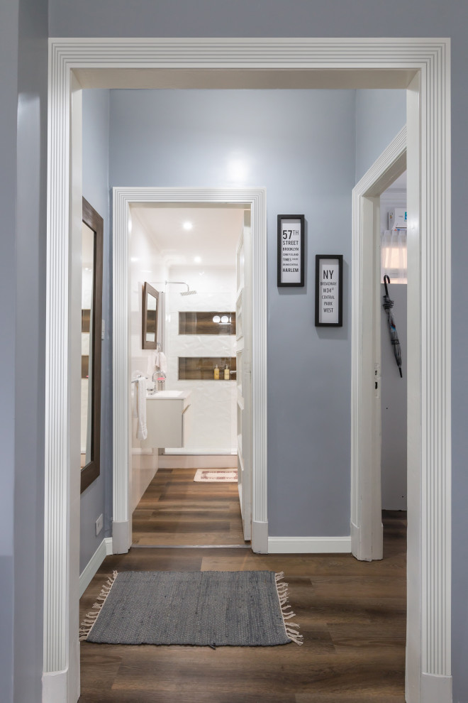 Cette image montre un couloir traditionnel de taille moyenne avec un mur bleu, parquet foncé, un sol marron et un plafond voûté.