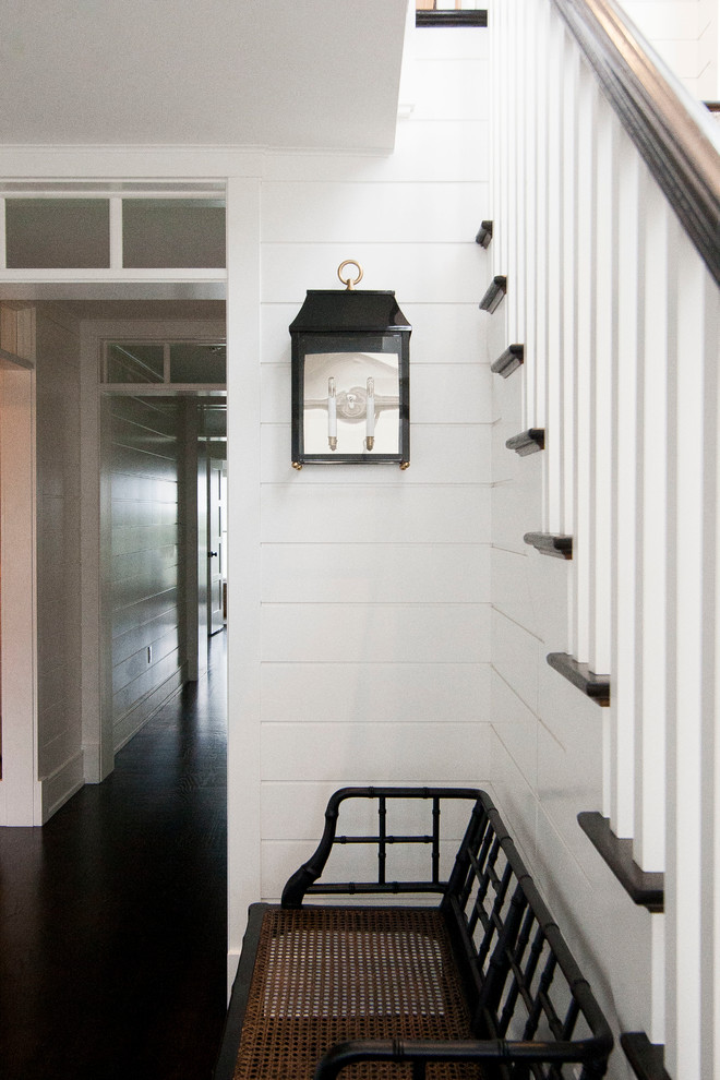 Cette photo montre un couloir avec un mur blanc et parquet foncé.