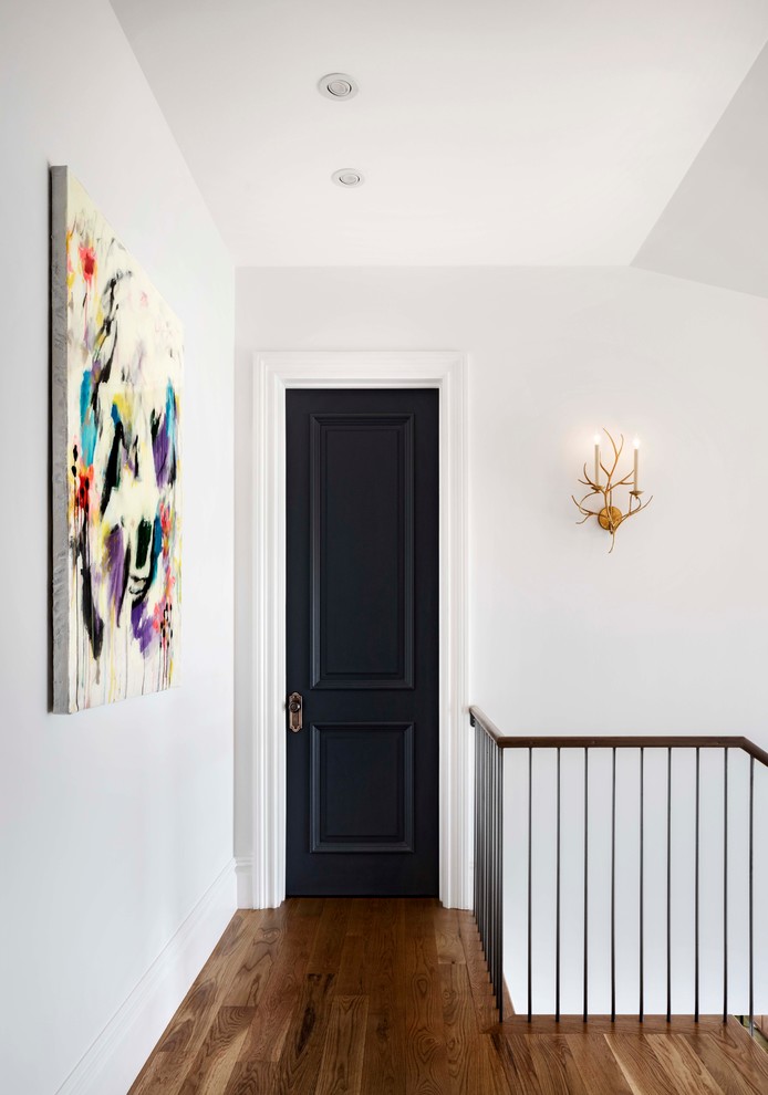 Idée de décoration pour un couloir tradition de taille moyenne avec un mur blanc et un sol en bois brun.