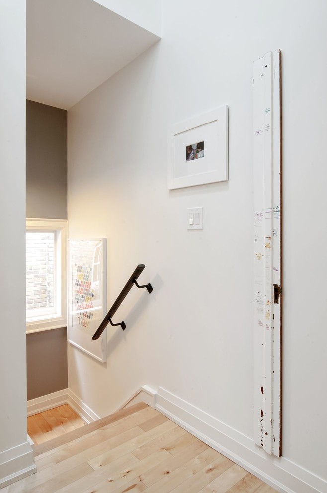 Cette image montre un couloir traditionnel de taille moyenne avec un mur blanc, parquet clair et un sol beige.