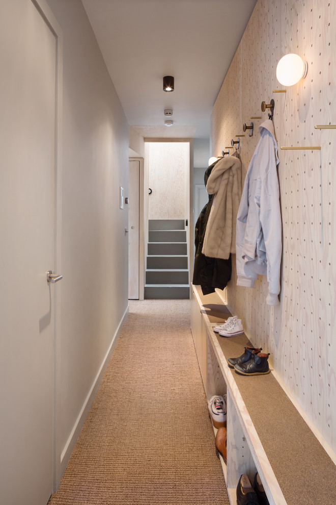 Cette photo montre un couloir tendance de taille moyenne avec un mur gris, moquette et un sol marron.