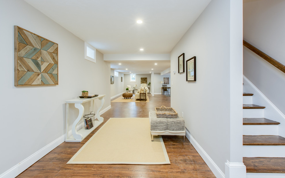 Esempio di un ingresso o corridoio chic di medie dimensioni con pareti grigie, pavimento in legno massello medio e pavimento marrone