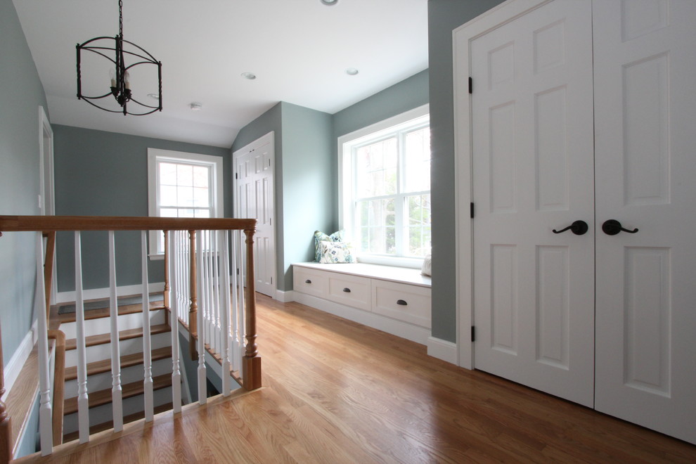 Example of a mid-sized transitional medium tone wood floor and brown floor hallway design in Boston with blue walls