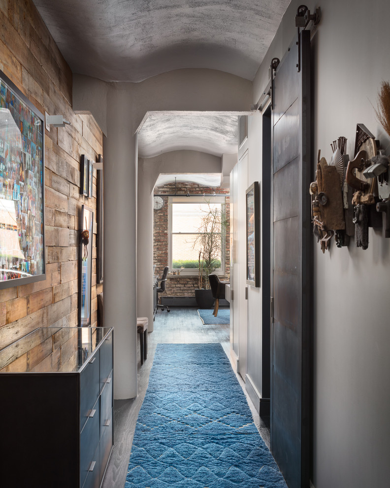 На фото: коридор в стиле лофт с серыми стенами, паркетным полом среднего тона и серым полом