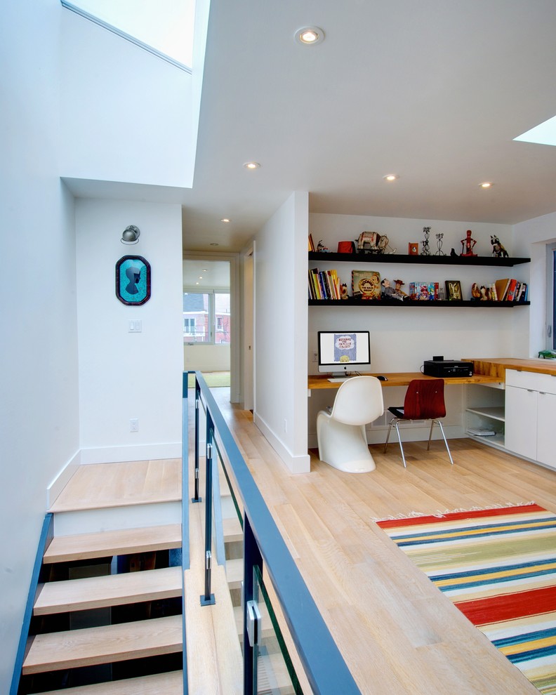 Example of an eclectic light wood floor hallway design in Toronto with white walls