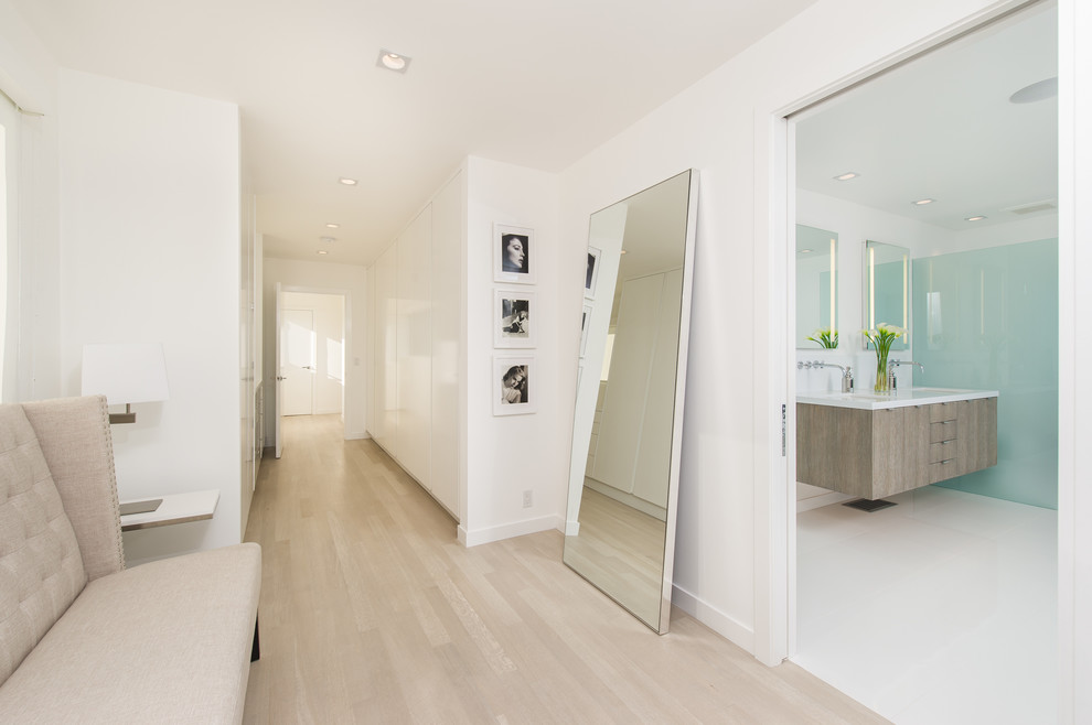 Aménagement d'un couloir contemporain avec un mur blanc, parquet clair et un sol beige.