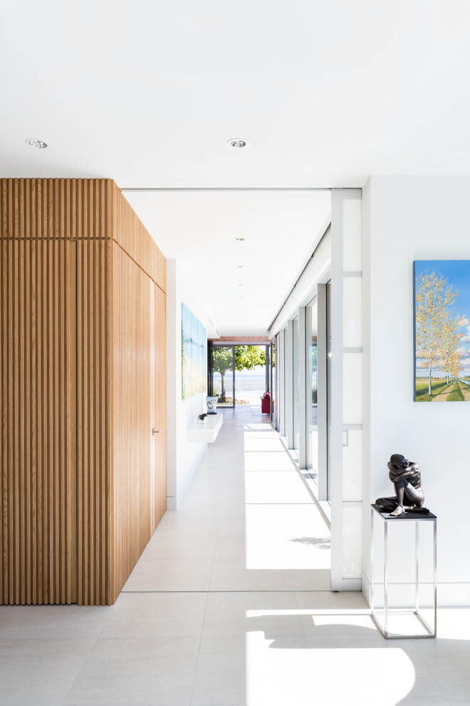Свежая идея для дизайна: коридор: освещение в современном стиле с белыми стенами и полом из керамогранита - отличное фото интерьера
