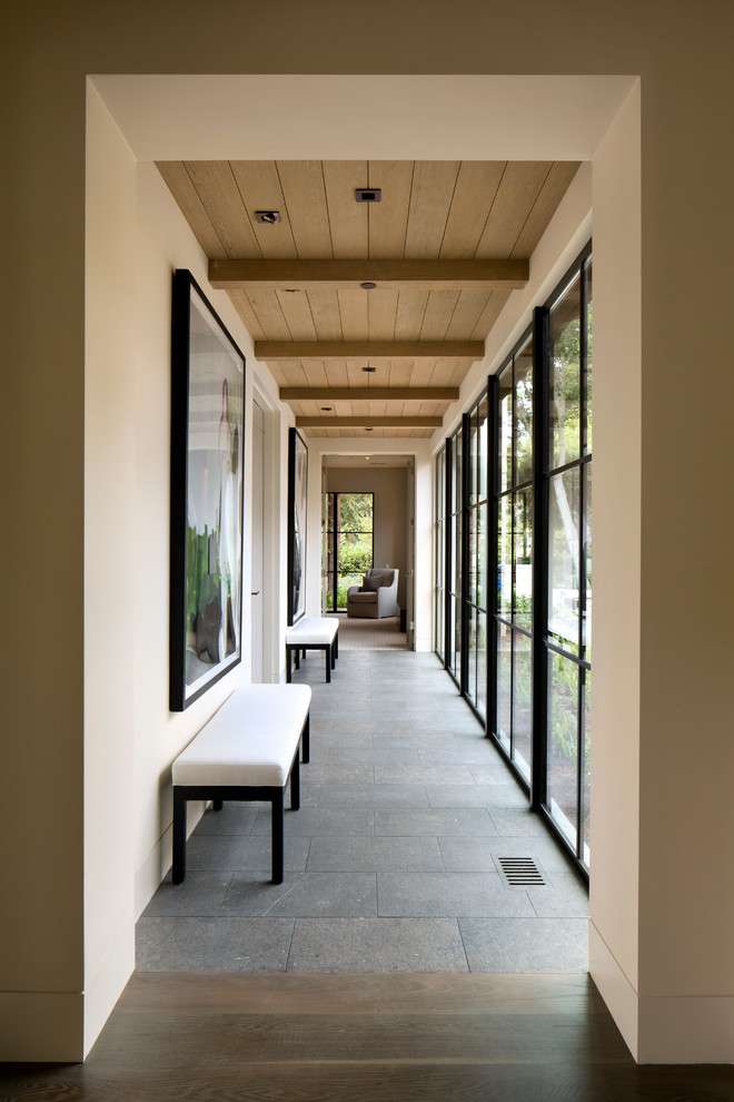 На фото: коридор среднего размера в стиле модернизм с бежевыми стенами, полом из сланца и серым полом