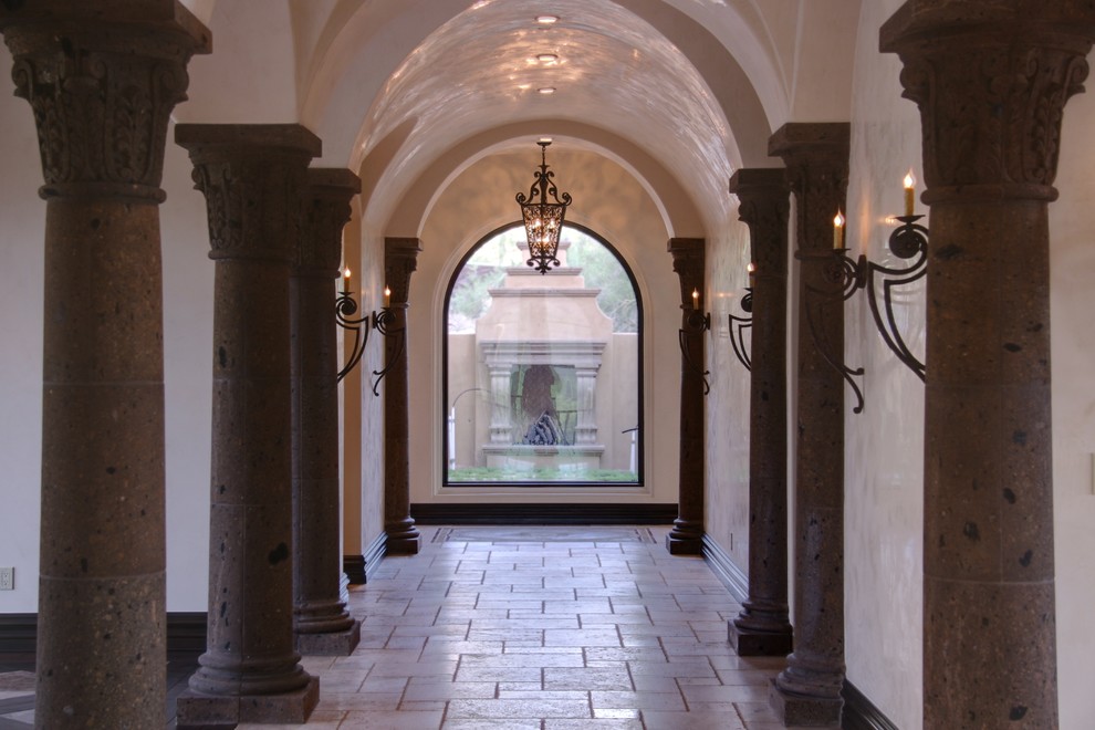 Aménagement d'un très grand couloir classique avec un mur beige et un sol en travertin.