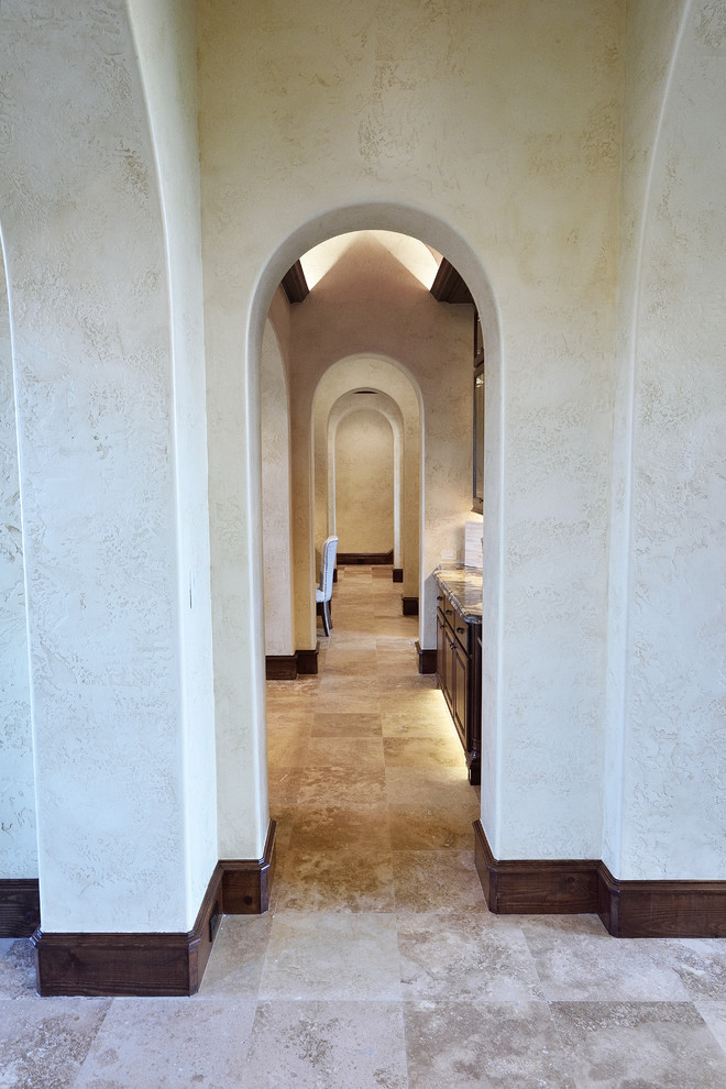 Large tuscan travertine floor and beige floor hallway photo in Houston with beige walls