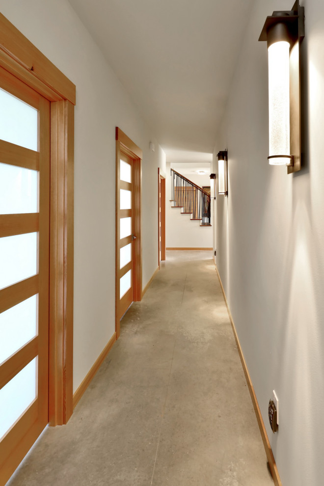 Imagen de recibidores y pasillos rústicos grandes con paredes blancas, suelo de cemento y suelo gris