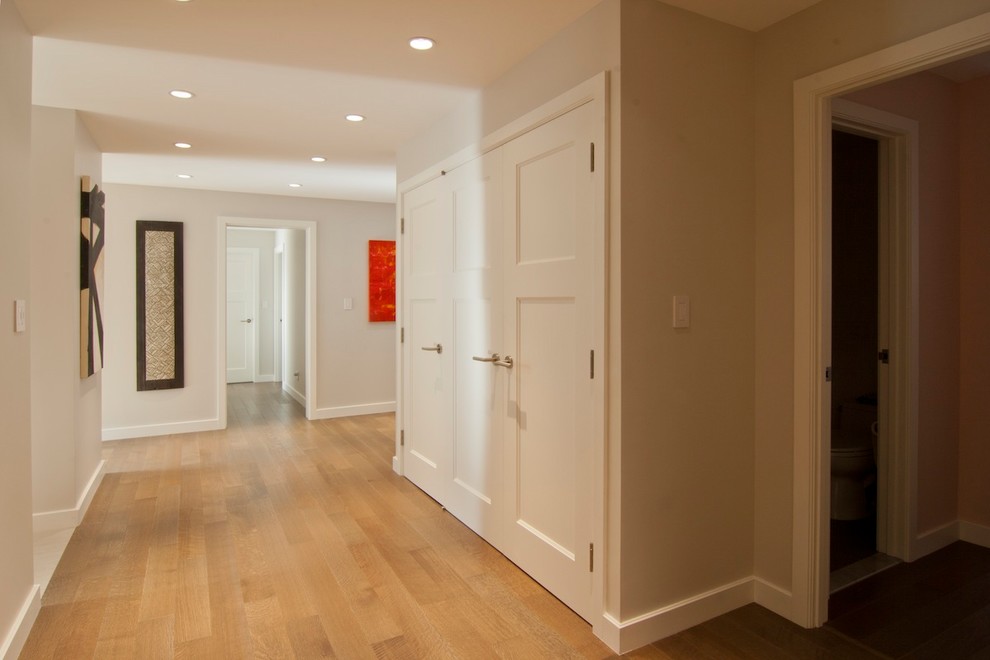 Cette image montre un couloir traditionnel de taille moyenne avec un mur beige, parquet clair et un sol beige.