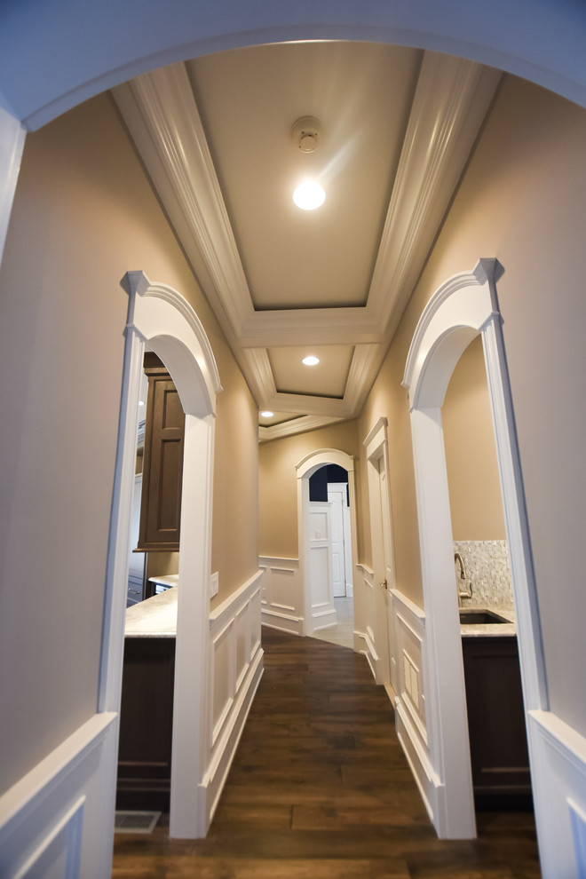 Inspiration pour un grand couloir traditionnel avec un mur beige, parquet foncé et un sol beige.