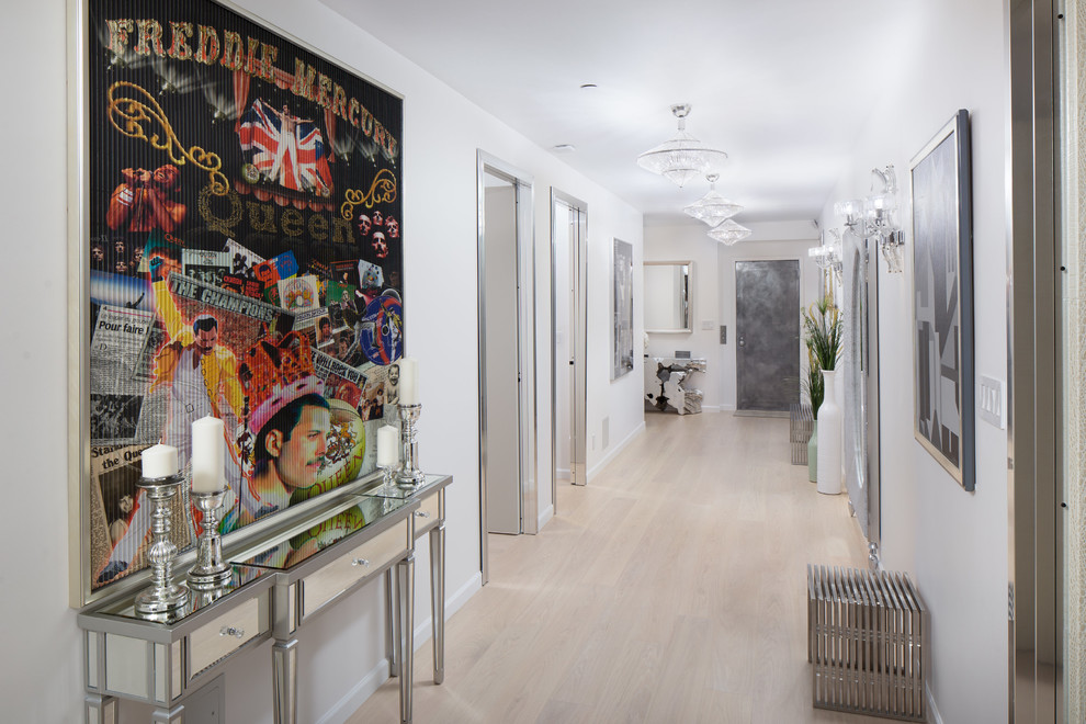 Example of a large trendy light wood floor and gray floor hallway design in New York with white walls