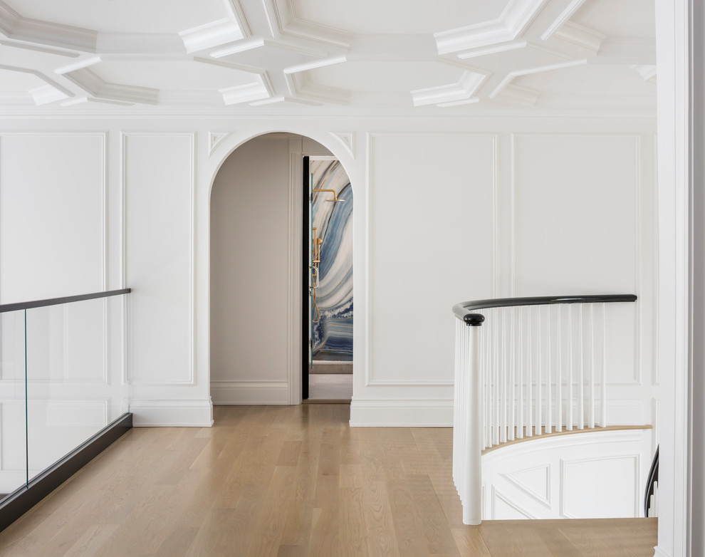 Imagen de recibidores y pasillos clásicos renovados grandes con paredes blancas, suelo de madera clara y suelo beige