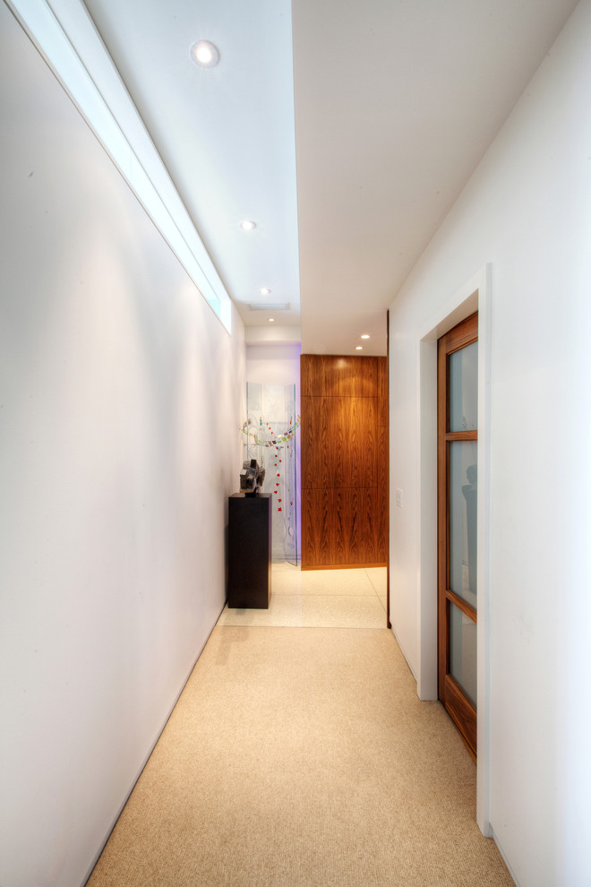 На фото: коридор среднего размера в стиле модернизм с белыми стенами и ковровым покрытием с