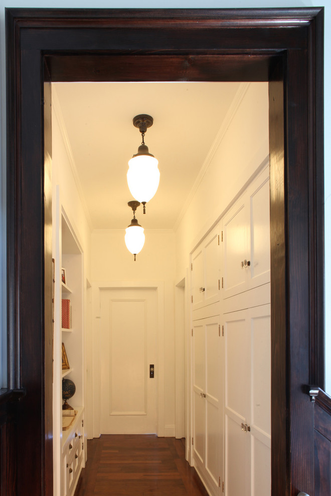 Mid-sized arts and crafts dark wood floor and brown floor hallway photo in Los Angeles with white walls
