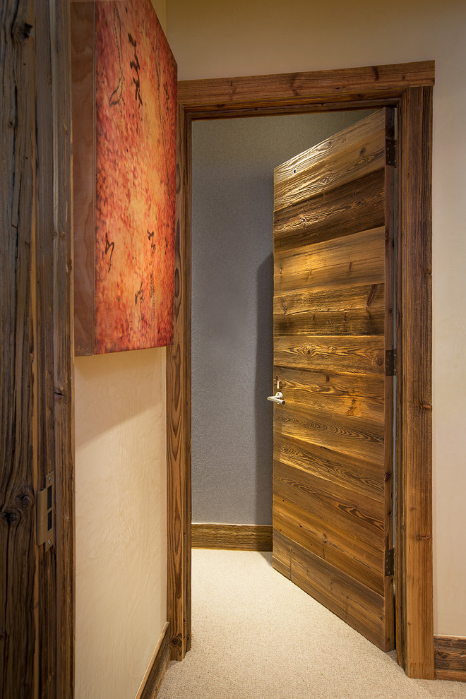 Inspiration for a mid-sized rustic carpeted hallway remodel in Denver with beige walls