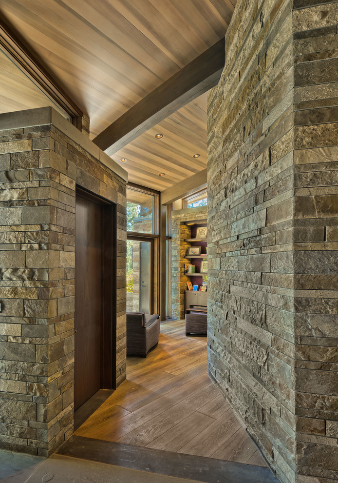Inspiration pour un couloir chalet de taille moyenne avec un mur beige et un sol en bois brun.