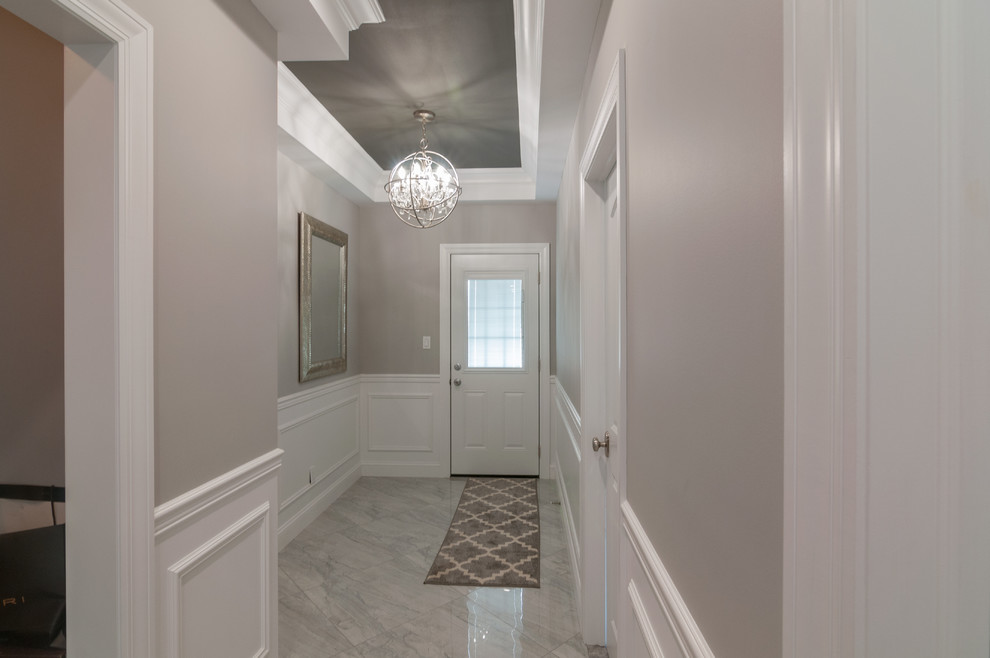 Idée de décoration pour un couloir minimaliste de taille moyenne avec un mur gris, un sol en carrelage de céramique et un sol gris.