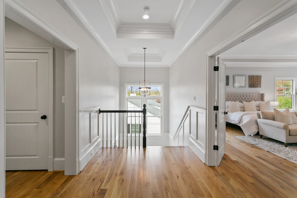 Esempio di un ingresso o corridoio minimal di medie dimensioni con pareti bianche, pavimento in legno massello medio e pavimento marrone