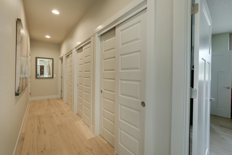 Hallway - large craftsman light wood floor hallway idea in Portland with beige walls