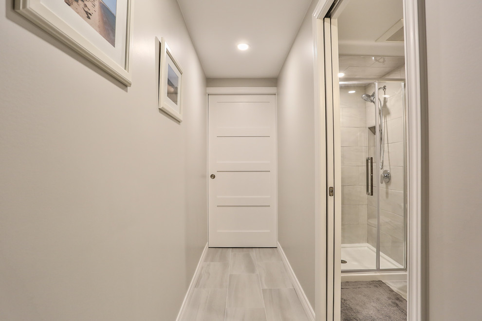 Exemple d'un petit couloir chic avec un mur gris, un sol en carrelage de porcelaine et un sol gris.