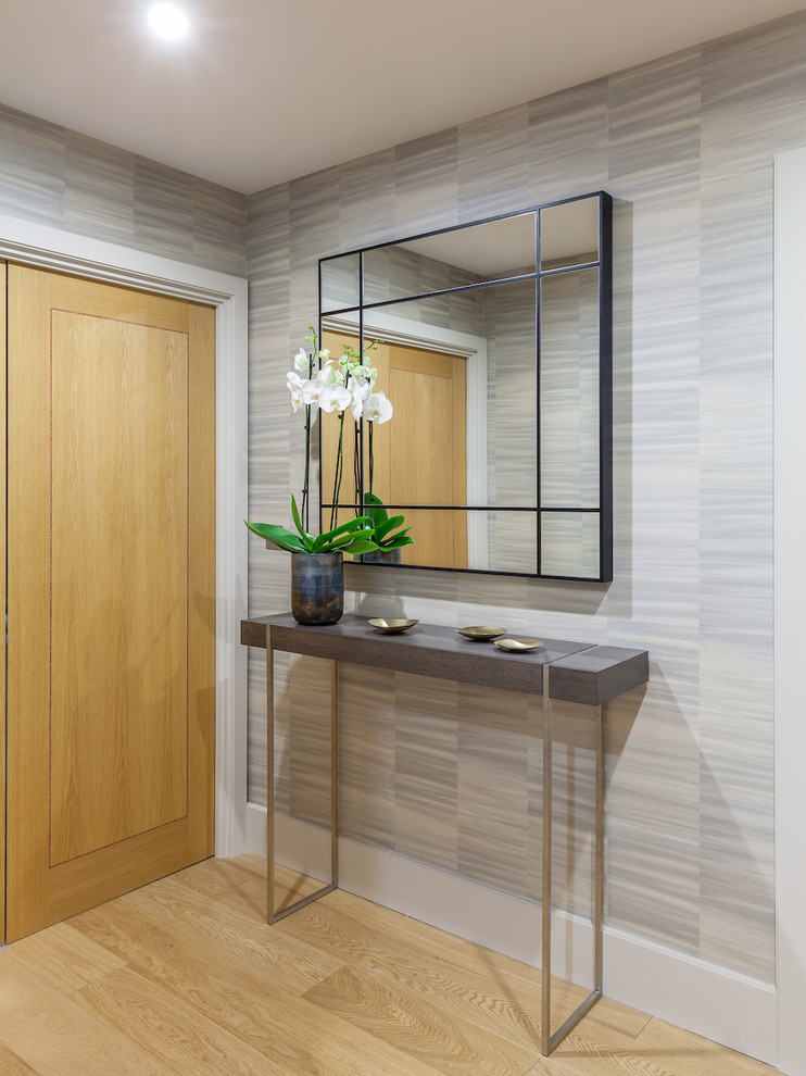 Inspiration pour un couloir design de taille moyenne avec un mur gris et un sol en bois brun.