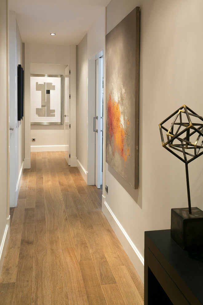 Hallway - mid-sized traditional medium tone wood floor hallway idea in Madrid with white walls