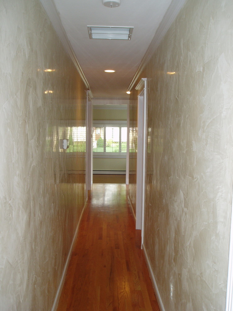 Mid-sized elegant medium tone wood floor hallway photo in Denver with beige walls
