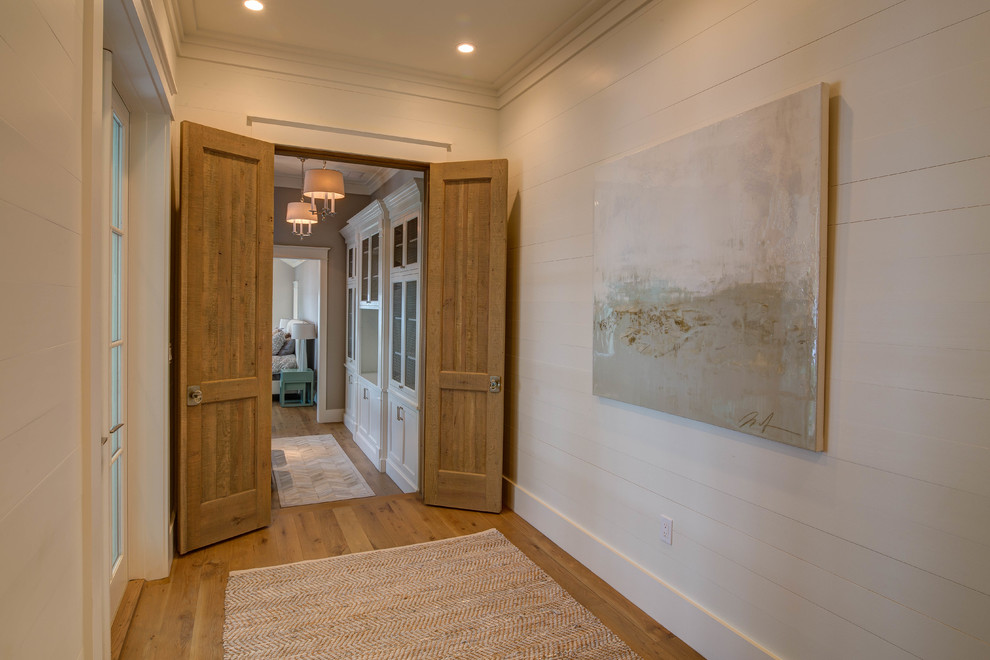 Immagine di un ingresso o corridoio stile marinaro con pareti bianche e parquet chiaro