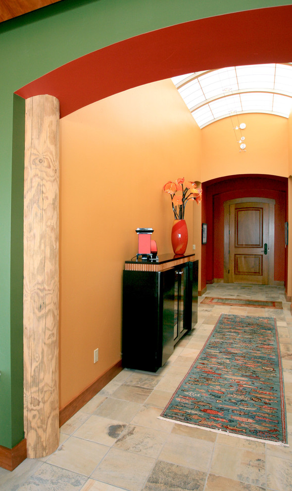 Idée de décoration pour un couloir design avec un mur jaune et un sol en travertin.
